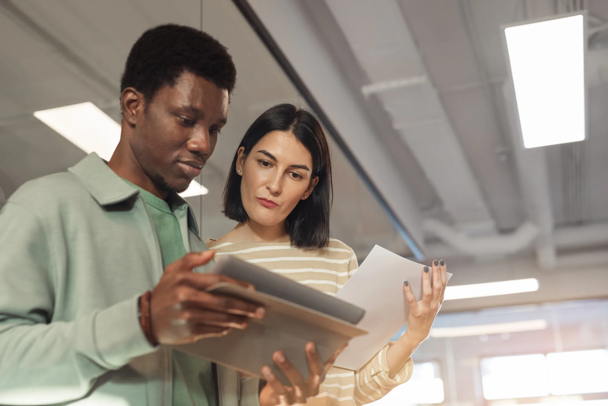 Two colleagues reviewing figures together on a tablet